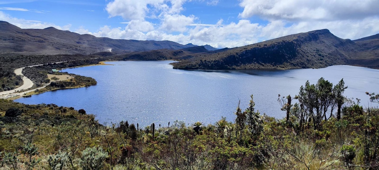 Laguna del páramo de Sumapaz rodeada de frailejones bajo un cielo azul